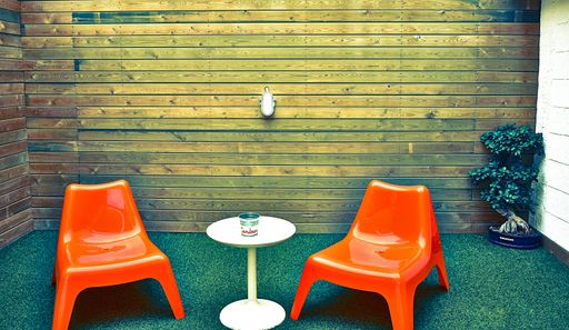 A beautiful shot of a minimalistic small room with two chairs and a table