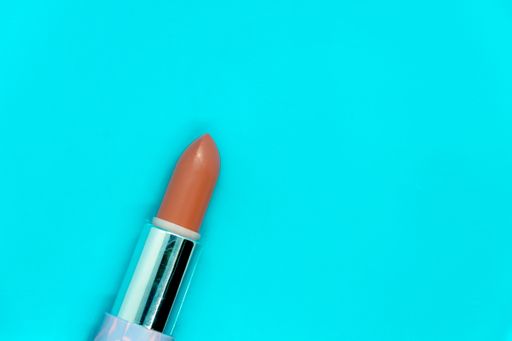 A top view of brown lipstick isolated on blue background