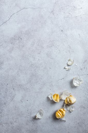 A vertical top view shot of garlic on a concrete surface