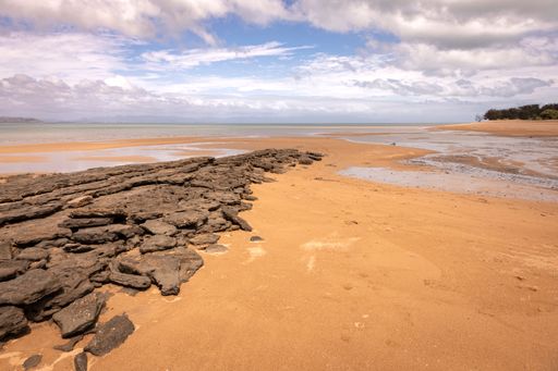 A serene landscape featuring a sandy beach at West Point on Magnetic Island, located off the coast of Townsville in Far North Queensland, Australia