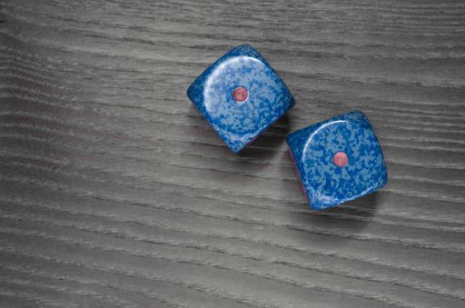 An overhead shot of two dice on a wooden surface