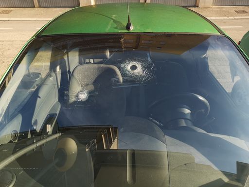 A view of a car's windshield damaged by hail