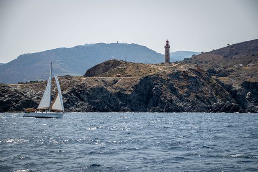 A sea with a ship and rocky port covered with Lighthouse in Cap Bear near to Port Vendres, France