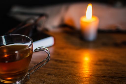 A high angle shot of star anise tea with a candle on a wooden table