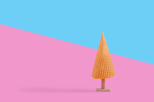 Creative concept with an ice cream cone as a Christmas tree on a colorful background