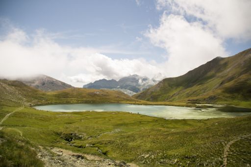 A lake in the middle of a mountainous scenery under the cloudy sky