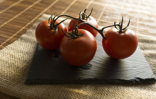 A closeup shot of fresh red juicy tomatoes attached to each other