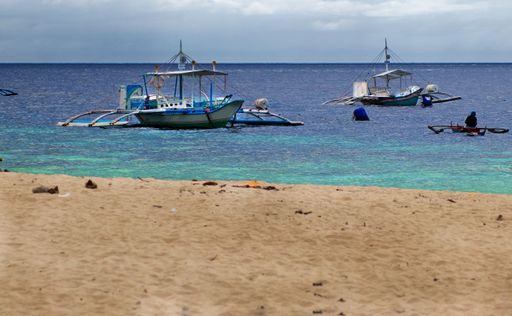 A scenery of traditional fishing boats at White Beach, Moaboal, Cebu, Philippines