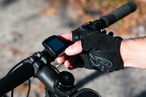 A high angle shot of a cyclist adjusting his bike's GPS