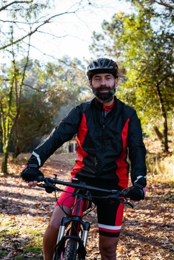 A vertical shot of a cyclist riding his bike in a forest