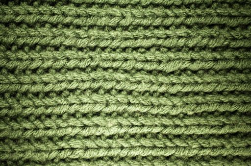 A closeup shot of a handmade green colored wool knitted fabric