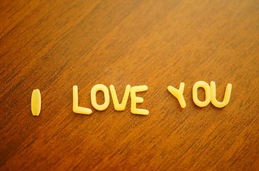 I love you written in noodle letters on wooden surface