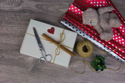 A high angle shot of a toy and Christmas presents on a wooden surface