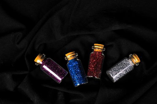 A high angle shot of colorful sparkes in bottles on a black surface