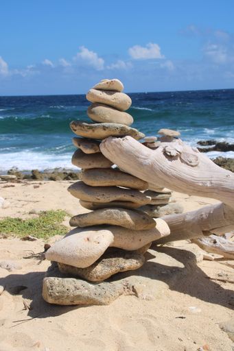 A vertical shot of some rocks on top of each other at a beach in Curacao
