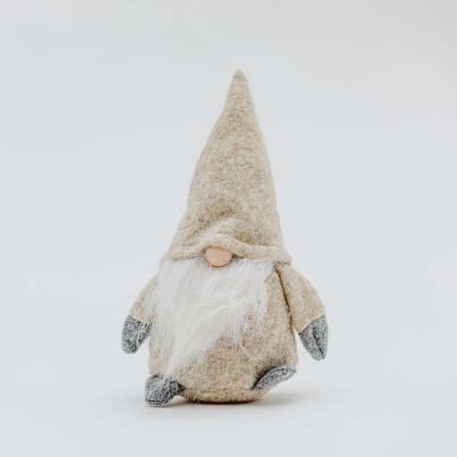 A cute Christmas toy in the shape of a soft beige gnome