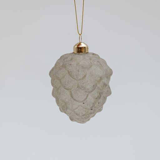A white Christmas tree toy in the shape of a fir cone