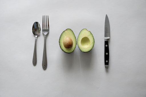 A high angle shot of a fresh delicious avocado with silverware