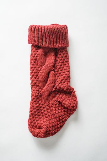 A vertical high angle shot of a knitted sock on a white surface