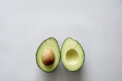 A high angle shot of fresh delicious avocado on a white surface