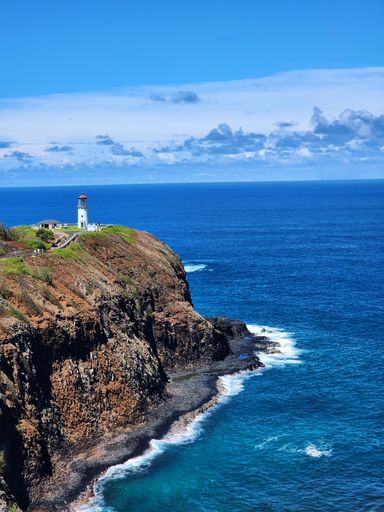 An aerial shot of the Kilauea Lighthouse on the edge of a cliff located in Kauai Hawaii
