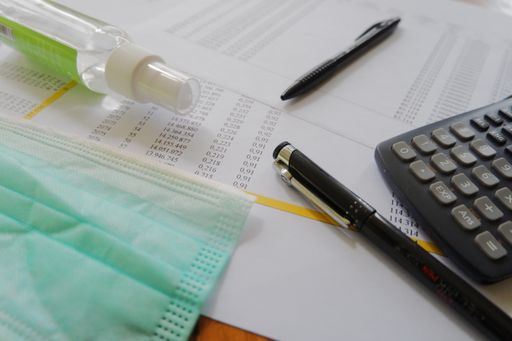 The office desk with safety mask and instant hand sanitizer- the concept of new normal