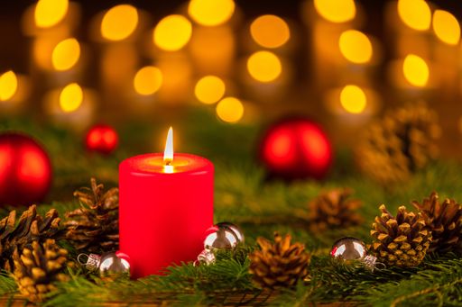 A selective focus shot of Christmas ornaments and a candle