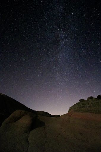 A vertical shot of a rocky scenery under the magical night sky