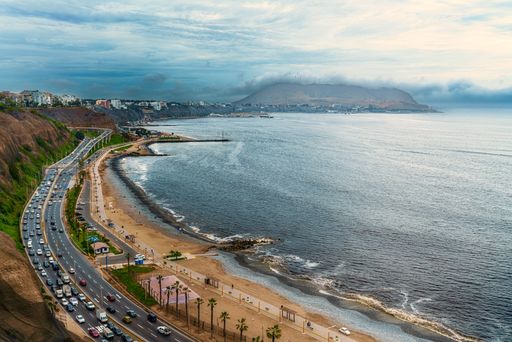 A high angle shot of a breathtaking view of a road by the sea on a cloudy day