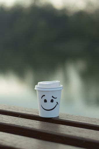 A closeup shot of a coffee cup on the bench