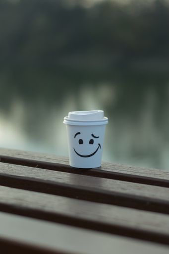 A closeup shot of a coffee cup on the bench