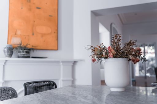 A modern kitchen with a vase with flowers on a gray marble table