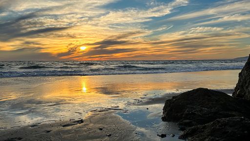 Wispy clouds fill the sunset over Venice Beach in Los Angeles, CA