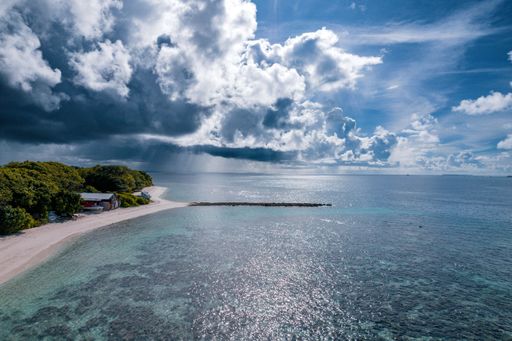 An aerial shot of the beautiful ocean and the Baa Kamadhoo beach in Maldives on a sunny day