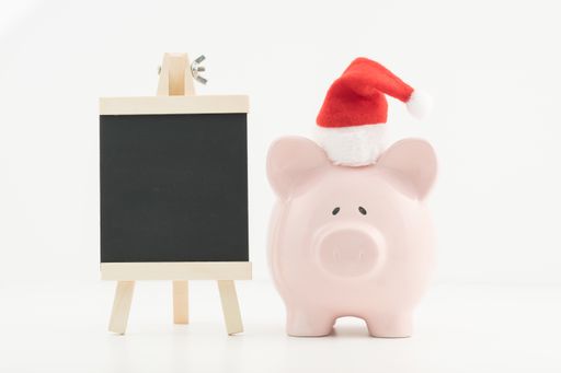 A piggy bank with a Santa Claus hat and a blackboard, the concept of budgeting, planning, and saving for the festive season