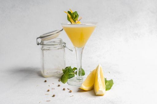A refreshing drink decorated with lemon peel and mint leaves