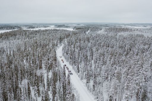 A high angle shot of cars driving through a mesmerizing snowy scenery in Finland