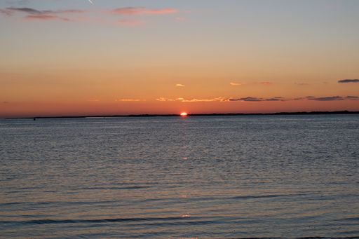 A calm seascape view with a setting down sunset sun on the horizon in  Norderney, Germany