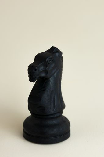 A closeup vertical shot of a chess single knight piece isolated on a white background