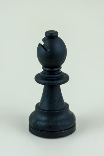 A closeup vertical shot of a chess single bishop piece isolated on a white background