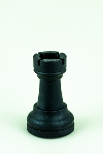 A closeup vertical shot of a chess single rook piece isolated on a white background