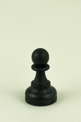 A closeup vertical shot of a chess single pawn piece isolated on a white background