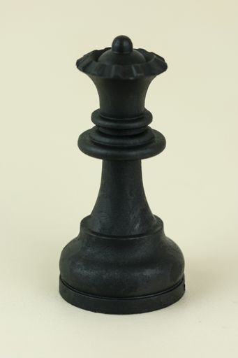 A closeup vertical shot of a chess single queen piece isolated on a white background