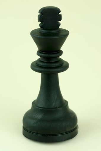 A closeup vertical shot of a chess single ki piece isolated on a white background