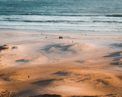 A scenery of people enjoying the day at the beach in Rio de Janeiro during sunset