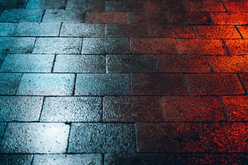 A red and blue light falling on the wet ground