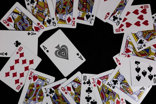 A top view of playing cards against a black background with the Ace of Spades in the middle