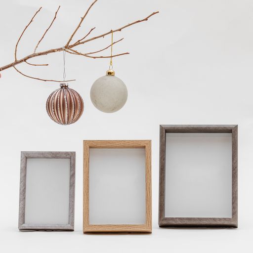 Three photo frames with a branch with Christmas toys