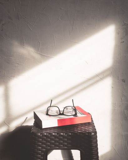 A vertical shot of glasses and a book on a chair
