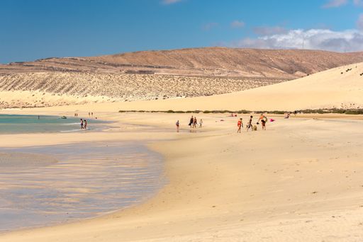 Sotavento, Fuerteventura, Spain: 2020 October 8: Young Blonde Woman walks through the dunes at Playa de Sotavento, Fuerteventura in Spain in summer.
